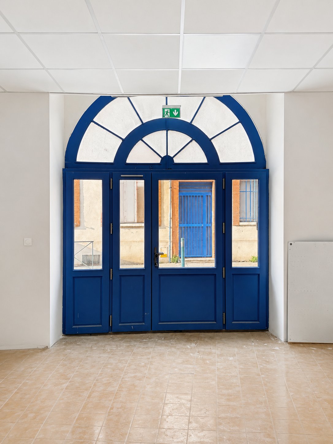 Zone de travail du local avec poteau bois et fenêtre sur rue